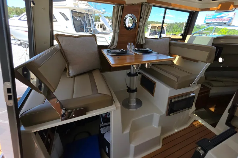 Slide: The Image of Interior of 2025 Ranger Tugs R-25, featuring a cozy dining area with cushioned seating. - 18