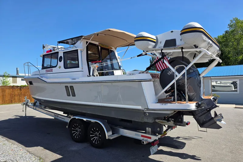 Slide: The Image of 2025 Ranger Tugs R-25 boat on trailer, featuring outboard motor and inflatable dinghy. - 4