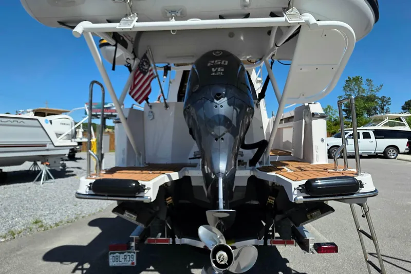 Slide: The Image of 2025 Ranger Tugs R-25 boat with powerful outboard motor, docked outdoors. - 6