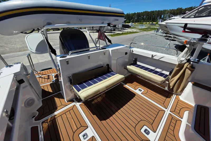 Slide: The Image of 2025 Ranger Tugs R-25 boat interior with foldable seating and teak flooring. - 8