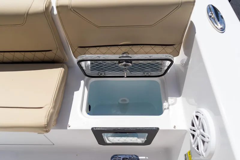 Slide: The Image of 2026 Sportsman Heritage 231 Center Console boat interior with open storage compartment and cushioned seating. - 16