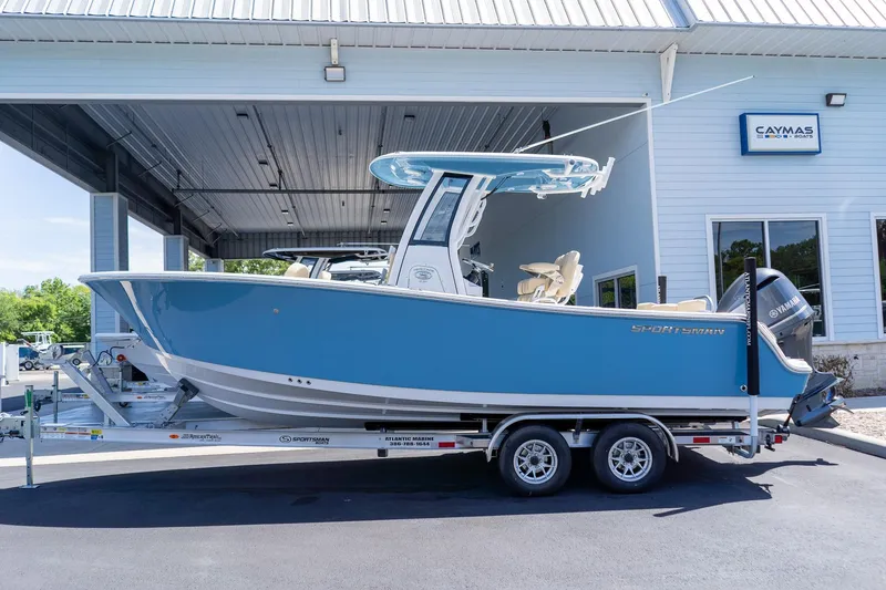 Slide: The Image of 2026 Sportsman Heritage 231 Center Console boat on trailer outside dealership. - 2