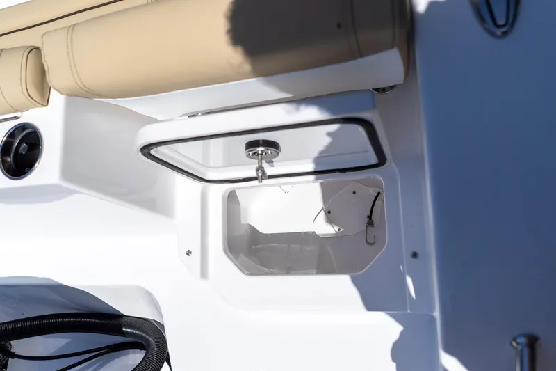 Slide: The Image of 2026 Sportsman Heritage 231 Center Console boat storage compartment with beige seating. - 34
