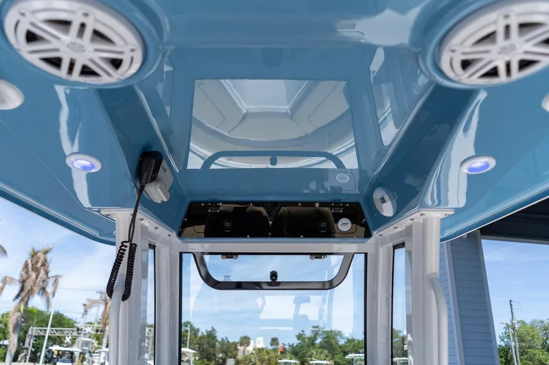 Slide: The Image of Interior view of 2026 Sportsman Heritage 231 Center Console boat, featuring speakers and blue ceiling. - 39