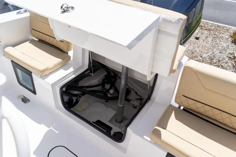 Slide: The Image of 2026 Sportsman Heritage 231 Center Console boat interior with storage compartment and beige seating. - 43