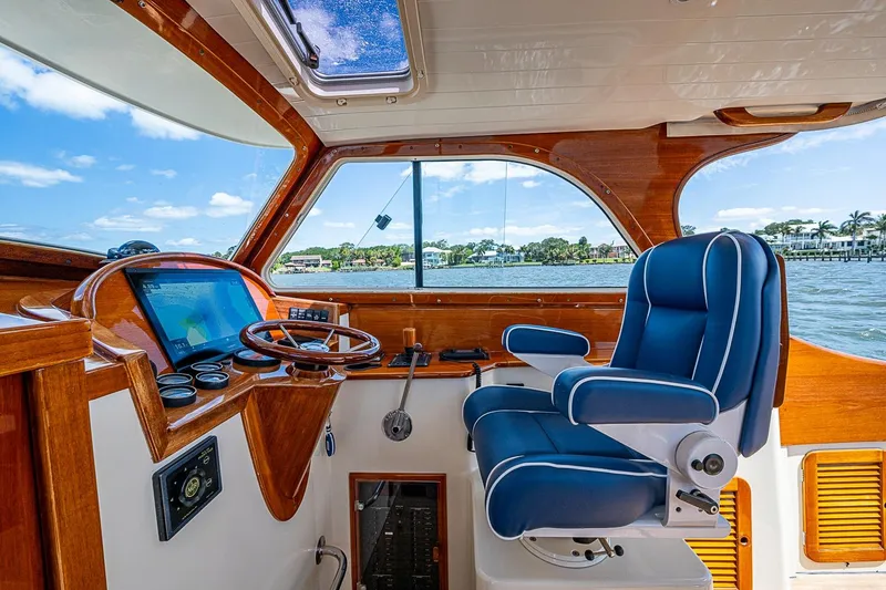 Slide: The Image of Interior of 2001 Hinckley Picnic Boat 36 Classic with blue captain's chair and navigation controls. - 11