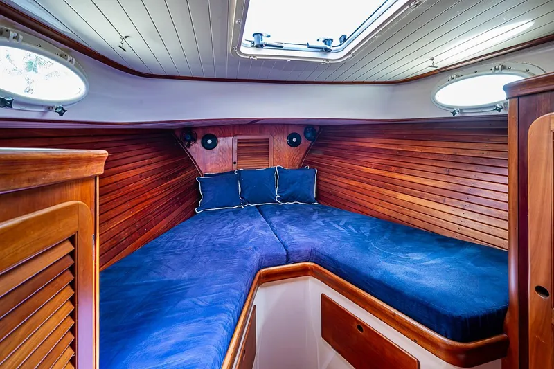 Slide: The Image of Interior cabin of 2001 Hinckley Picnic Boat 36 Classic with blue bedding and wooden paneling. - 16