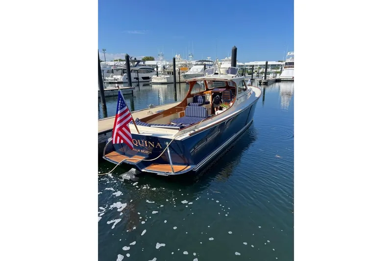 Slide: The Image of 2001 Hinckley Picnic Boat 36 Classic docked in a marina, displaying an American flag. - 5