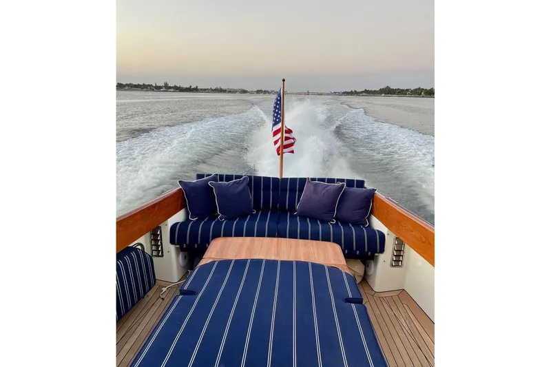 Slide: The Image of Hinckley Picnic Boat 36 Classic, 2001, cruising with American flag, striped seating, and scenic water view. - 7