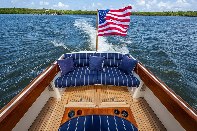 Slide: The Image of Hinckley Picnic Boat 36 Classic 2001 with American flag, cruising on open water. - 8