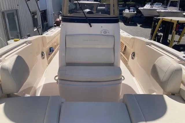 Slide: The Image of 2023 Grady-White Fisherman 236 boat interior with seating and console, docked outdoors. - 10