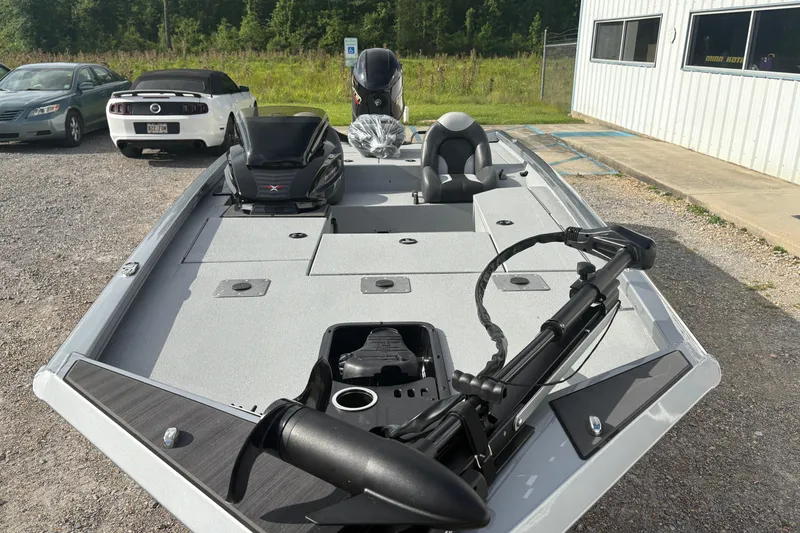 Slide: The Image of 2026 Vexus Defender 189 boat with sleek design, parked outdoors near vehicles. - 10