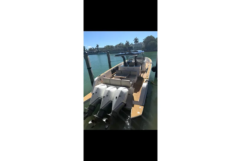 Slide: The Image of 2022 Pardo Yachts 38 docked, showcasing sleek design and powerful outboard engines. - 4