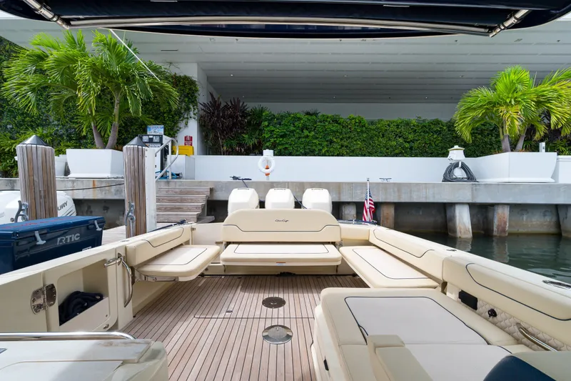 Slide: The Image of 2022 Chris-Craft Calypso 35 boat interior with seating, docked near lush greenery. - 27