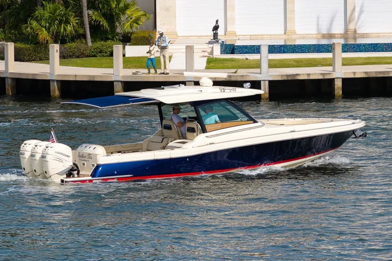 Slide: The Image of 2022 Chris-Craft Calypso 35 cruising on water near a dockside with palm trees. - 11