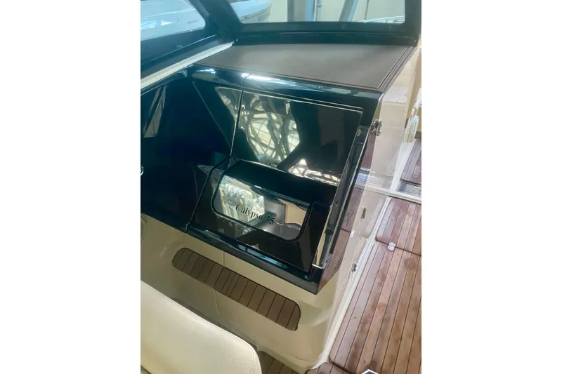 Slide: The Image of 2022 Chris-Craft Calypso 35 interior detail with sleek black cabinetry and wooden flooring. - 7