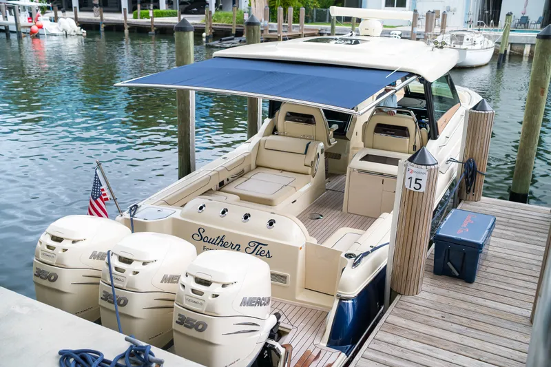 Slide: The Image of 2022 Chris-Craft Calypso 35 docked, featuring triple Mercury 350 engines and a spacious deck. - 29
