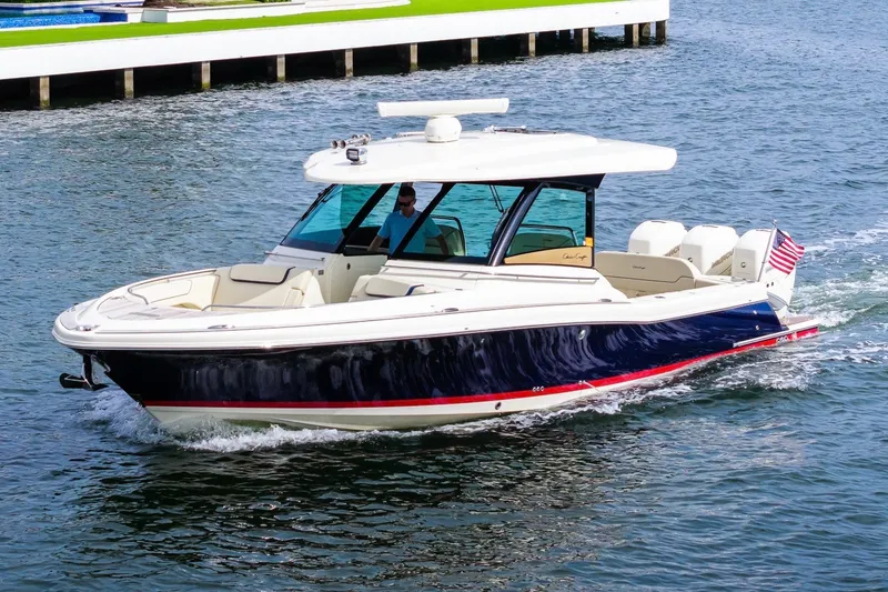 Slide: The Image of 2022 Chris-Craft Calypso 35 boat cruising on water with American flag. - 5