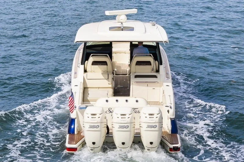 Slide: The Image of 2022 Chris-Craft Calypso 35 boat cruising on water, rear view with triple engines. - 8