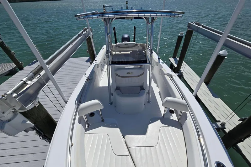 Slide: The Image of 2012 Sea Hunt Ultra 225 boat docked, showcasing spacious deck and sleek design. - 16
