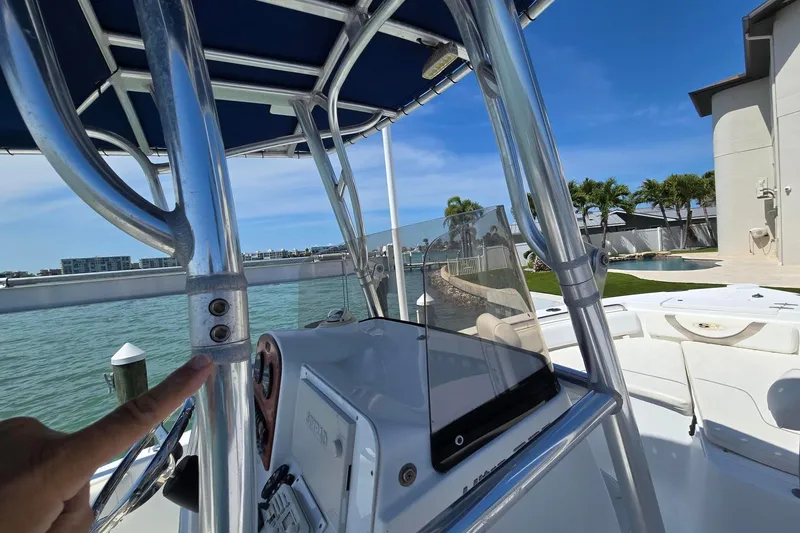 Slide: The Image of 2012 Sea Hunt Ultra 225 boat with T-top and console, docked by waterfront property. - 21