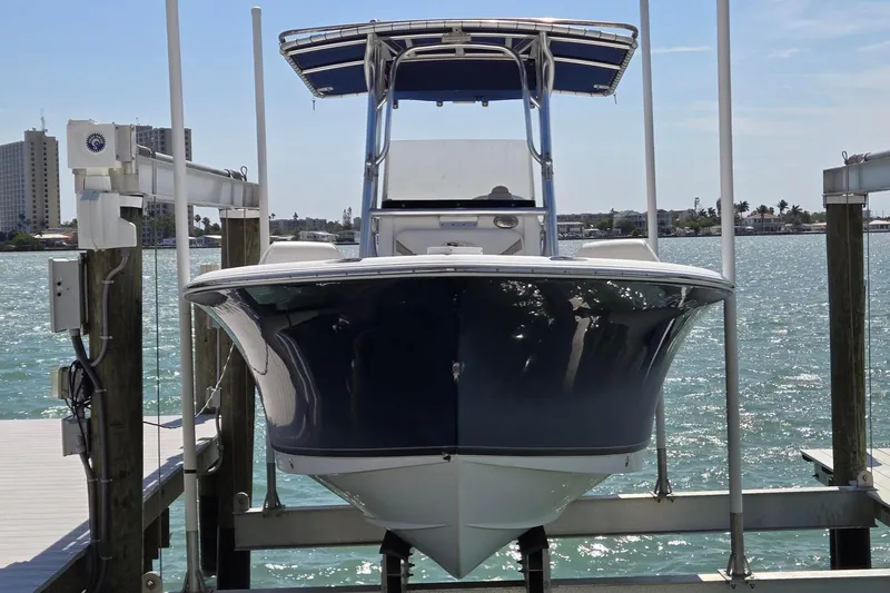 Slide: The Image of 2012 Sea Hunt Ultra 225 boat on lift, docked by waterfront buildings. - 3