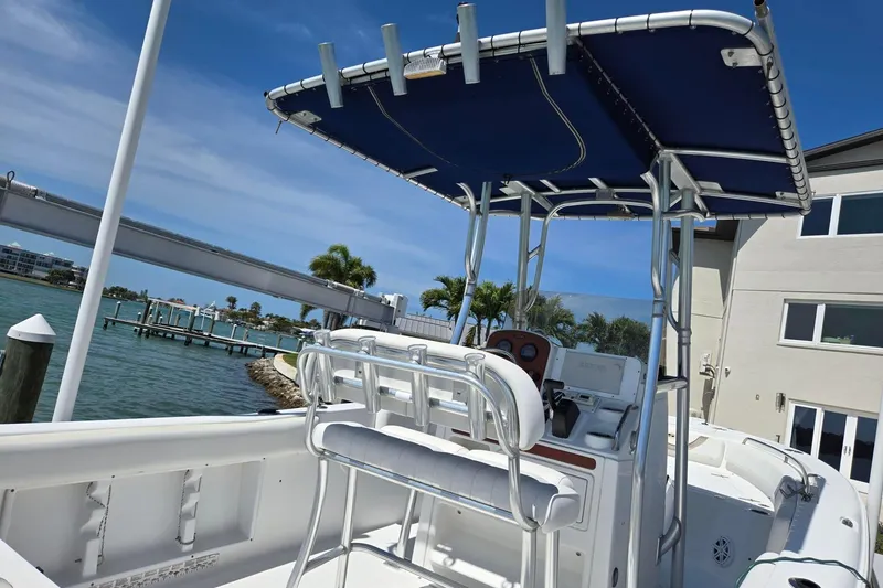Slide: The Image of 2012 Sea Hunt Ultra 225 boat with T-top, docked near waterfront homes. - 30