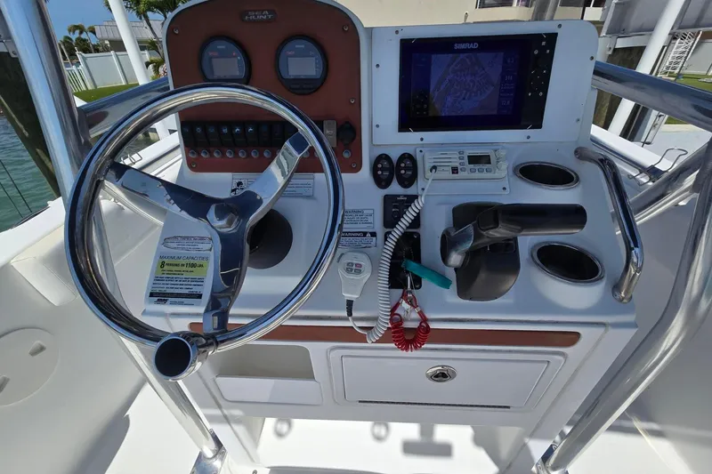 Slide: The Image of 2012 Sea Hunt Ultra 225 boat dashboard with steering wheel, controls, and navigation system. - 8