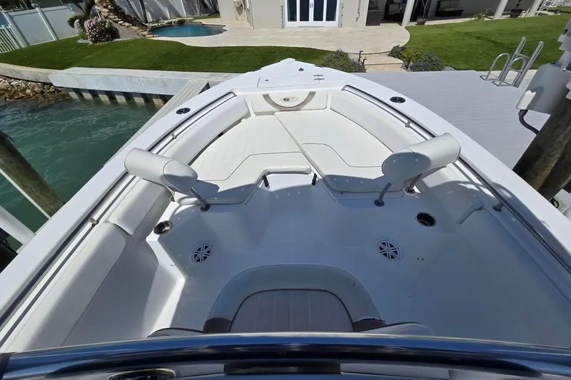 Slide: The Image of 2012 Sea Hunt Ultra 225 boat interior with seating, docked by waterfront property. - 9