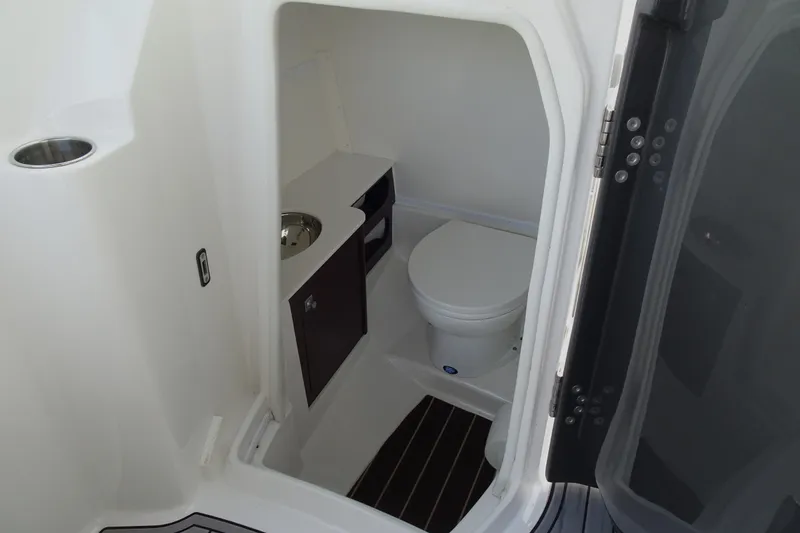Slide: The Image of Compact bathroom inside 2017 Monterey M-65 boat, featuring a toilet and sink. - 17