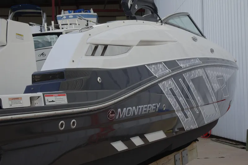 Slide: The Image of 2017 Monterey M-65 boat with sleek design and modern graphics, docked in a marina. - 5