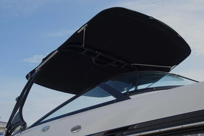 Slide: The Image of 2017 Monterey M-65 boat with sleek black canopy against blue sky. - 6