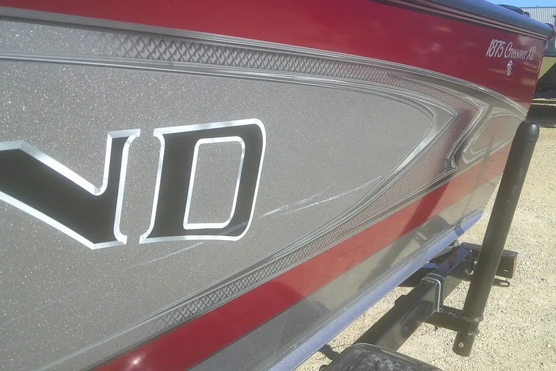 Slide: The Image of 2017 Lund 1875 Crossover XS boat with red and silver detailing on trailer. - 26