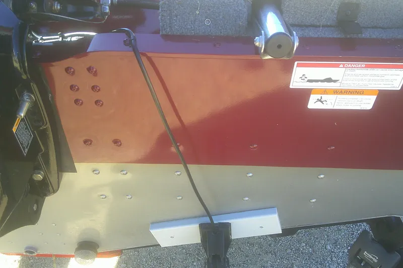 Slide: The Image of 2017 Lund 1875 Crossover XS boat transom with warning labels and mounting hardware. - 28