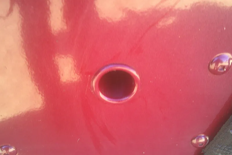 Slide: The Image of Close-up of a red 2017 Lund 1875 Crossover XS boat hull with a circular opening. - 29