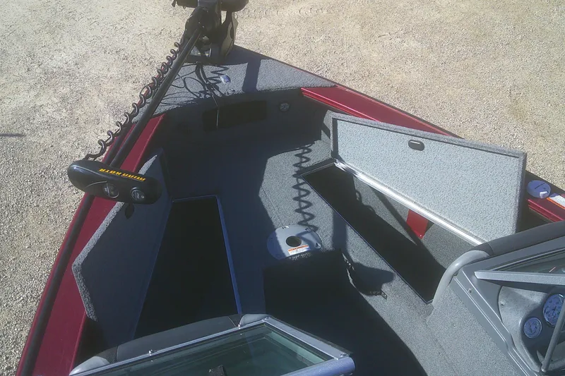 Slide: The Image of 2017 Lund 1875 Crossover XS boat interior with open storage compartments and trolling motor. - 9