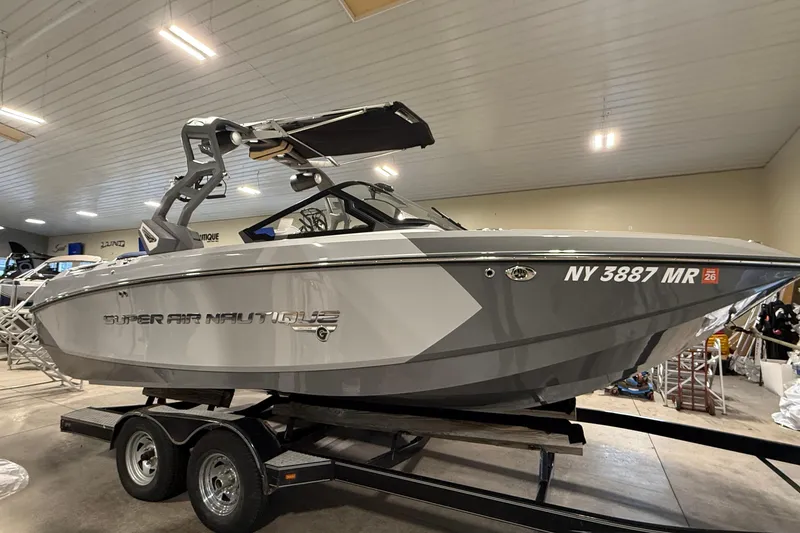 The Image of 2020 Nautique Super Air Nautique G21 boat on trailer in indoor showroom. - 0