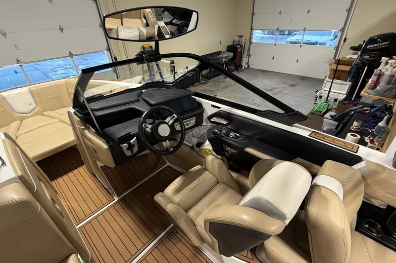 Slide: The Image of 2020 Nautique Super Air Nautique G21 boat interior with beige seating and modern dashboard. - 2