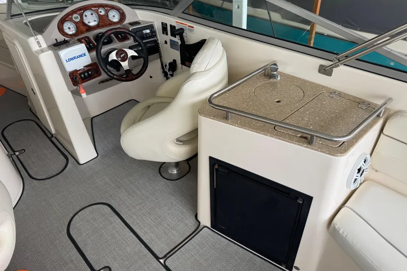 Slide: The Image of 2006 Rinker 282 Captiva Bowrider interior with steering wheel, dashboard, and kitchenette. - 13