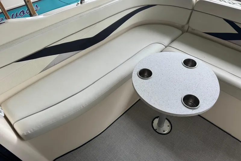 Slide: The Image of 2006 Rinker 282 Captiva Bowrider interior with cushioned seating and round table with cup holders. - 15