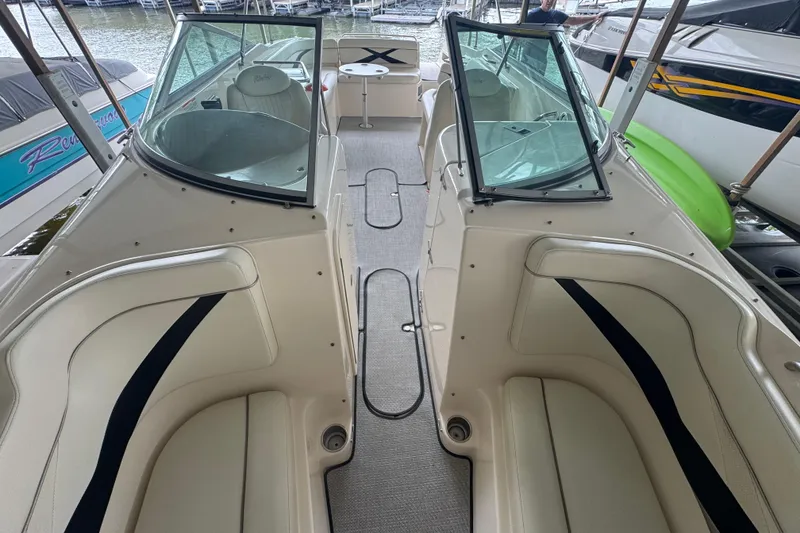 Slide: The Image of 2006 Rinker 282 Captiva Bowrider interior with seating and windshield, docked at marina. - 18