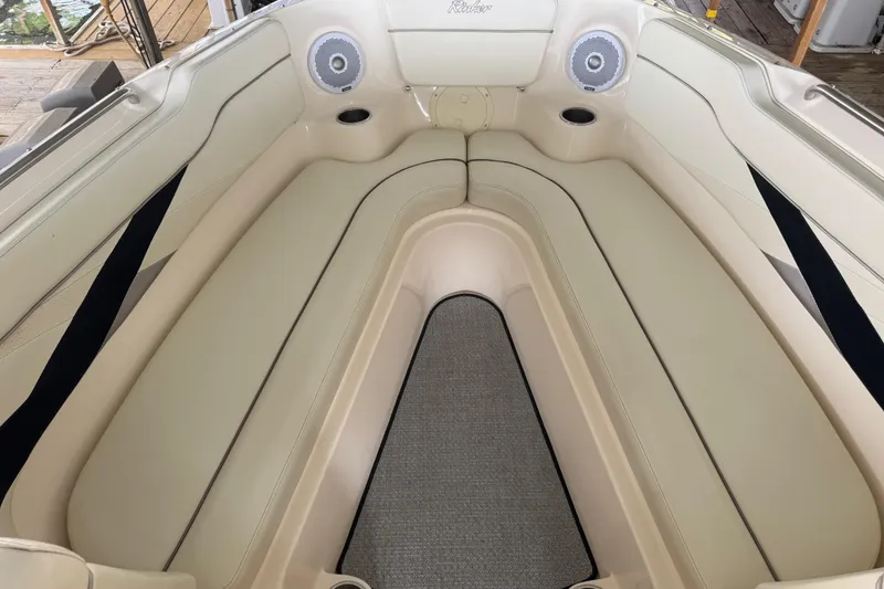 Slide: The Image of 2006 Rinker 282 Captiva Bowrider interior with beige seating and built-in speakers. - 19