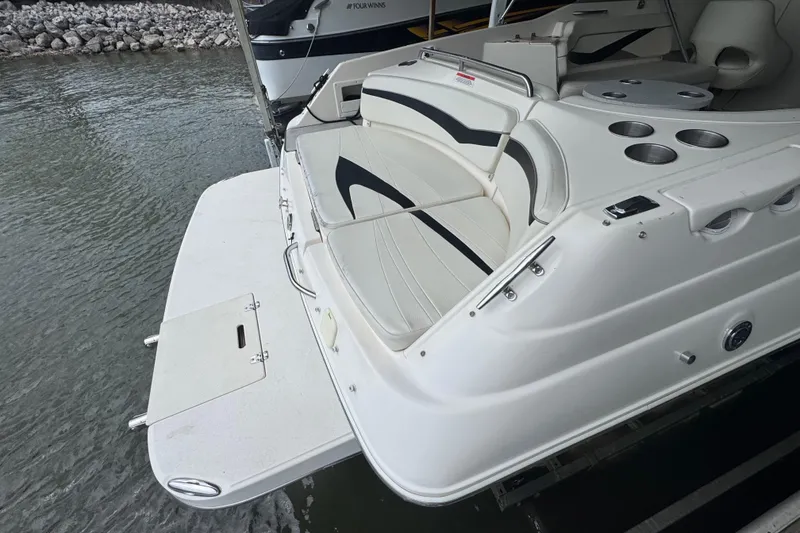 Slide: The Image of 2006 Rinker 282 Captiva Bowrider with spacious seating and cup holders, docked by the water. - 24