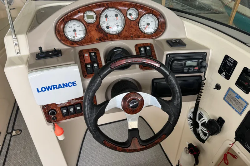 Slide: The Image of 2006 Rinker 282 Captiva Bowrider dashboard with steering wheel and navigation instruments. - 8
