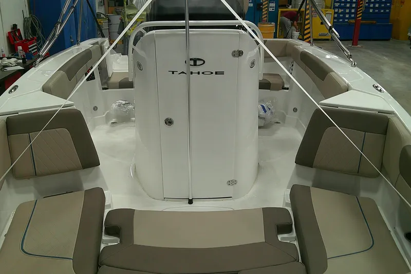 Slide: The Image of 2026 Tahoe 2150 CC boat interior with beige seating and white console in a workshop. - 14
