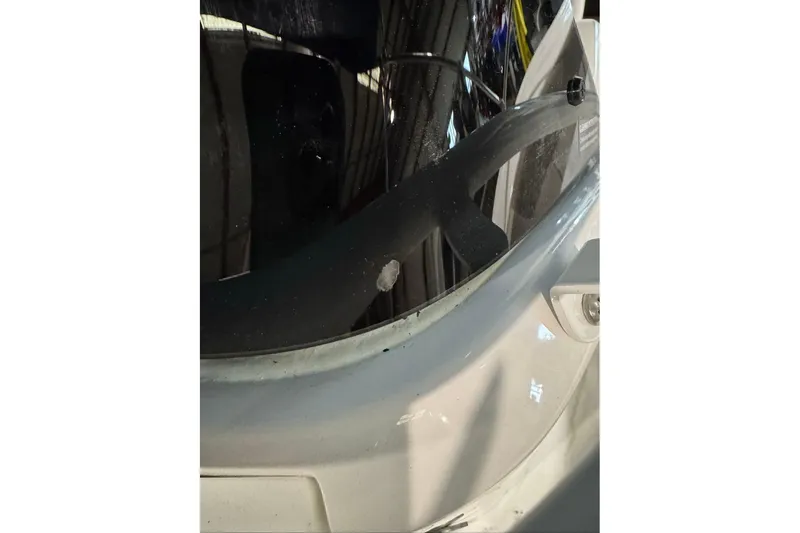 Slide: The Image of Close-up of 2026 Tahoe 2150 CC boat windshield with minor damage. - 2