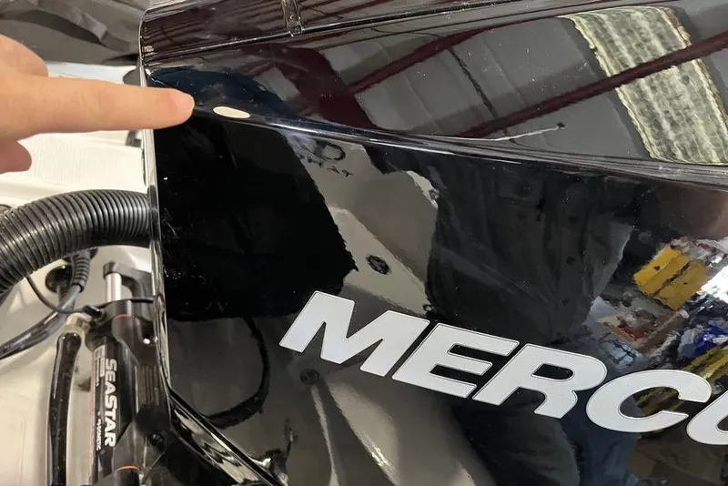 Slide: The Image of Close-up of a 2026 Tahoe 2150 CC boat engine with a finger pointing. - 8