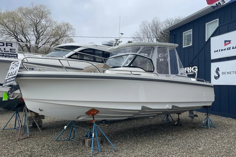 Slide: The Image of 2023 Nimbus Tender 8 boat for sale, displayed on stands outside dealership. - 2