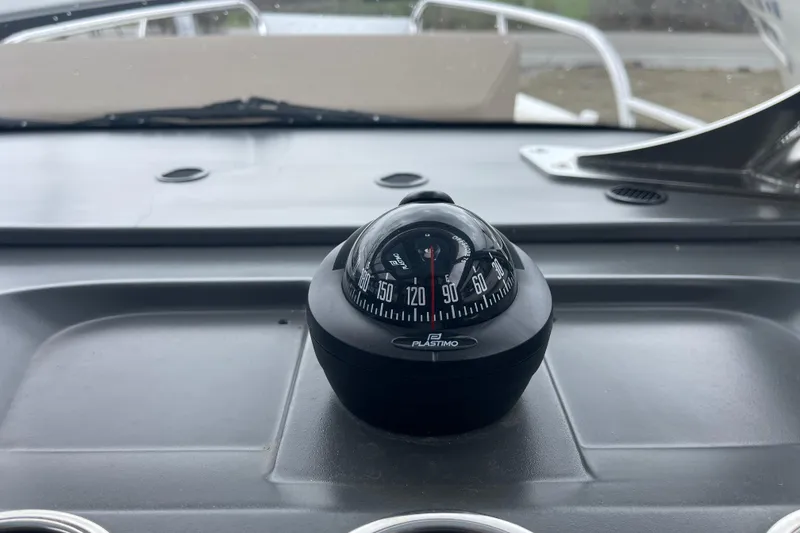 Slide: The Image of Compass on dashboard of 2023 Nimbus Tender 8 boat, featuring Plastimo brand. - 24