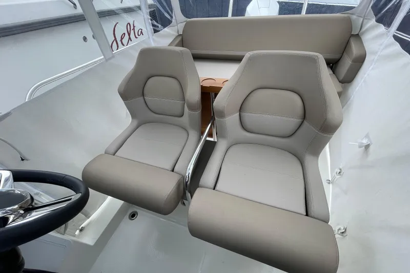 Slide: The Image of Interior of 2023 Nimbus Tender 8 boat with beige seating and steering wheel. - 29